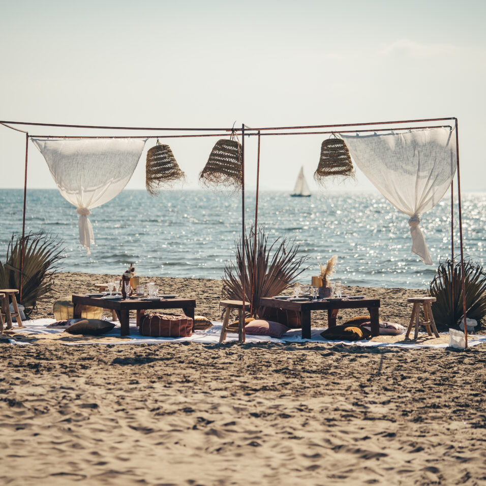 Banc de sable Bohème mobilier avec vue sur un catamaran au loin avec bokeh, Catamaran Lucile sorties en mer à la Grande Motte