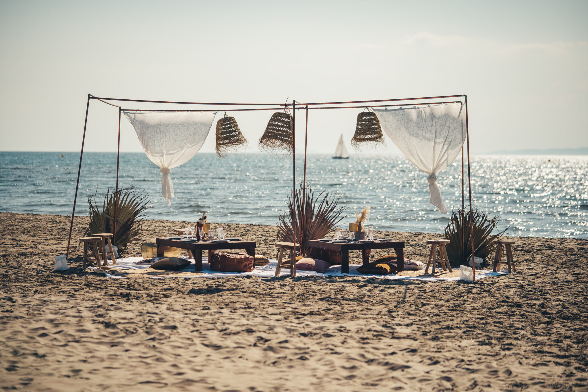 Banc de sable Bohème mobilier avec vue sur un catamaran au loin avec bokeh, Catamaran Lucile sorties en mer à la Grande Motte